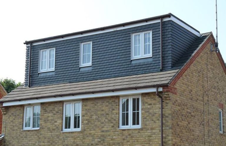 Two-storey house with a grey sloped roof and three windows on the upper floor.