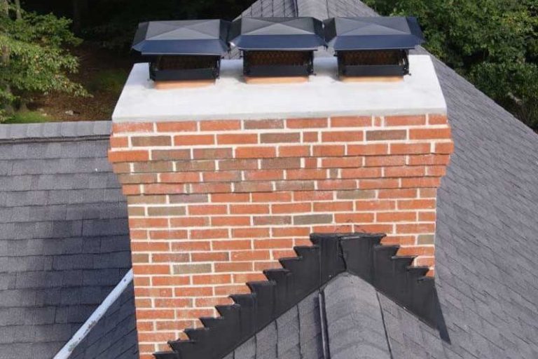 Brick chimney with three vents atop a sloped roof.